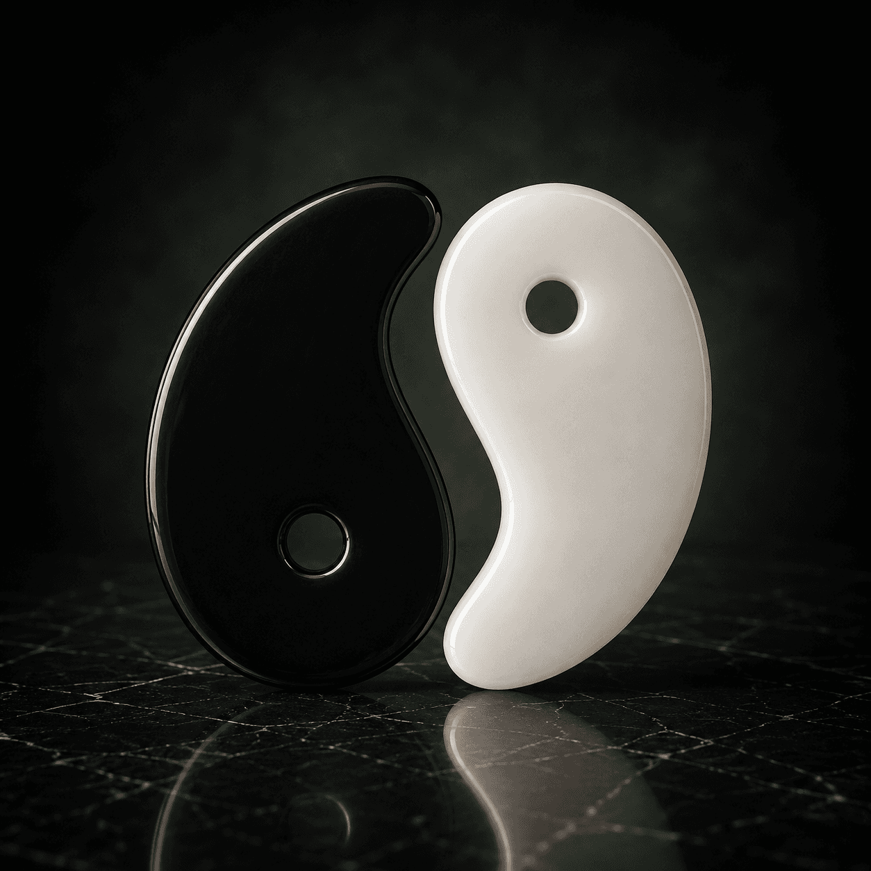 Vomando Gua Sha tools in black and white shown together on dark marble