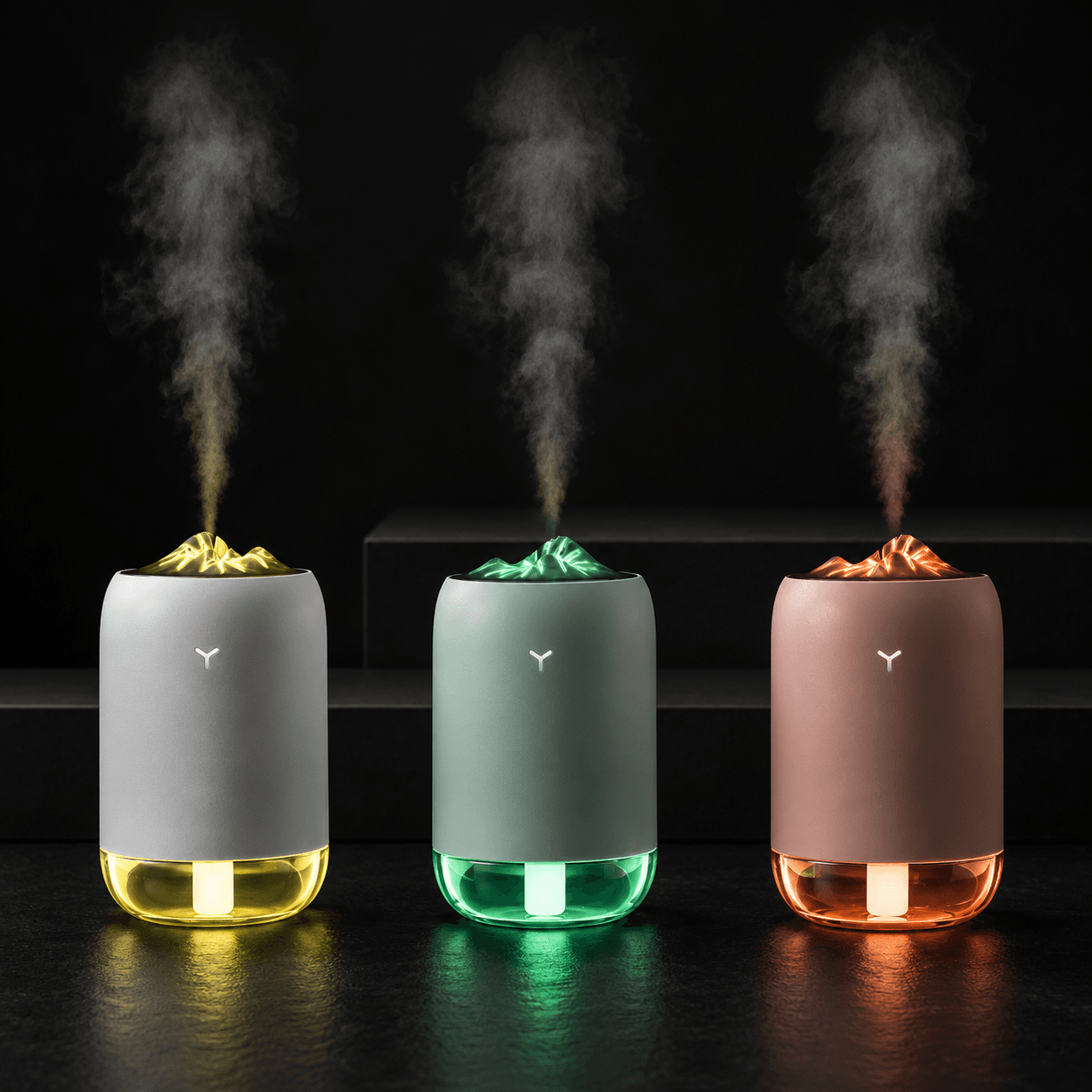 Vomando FlameMist humidifiers in white, light blue, and pink shown together misting