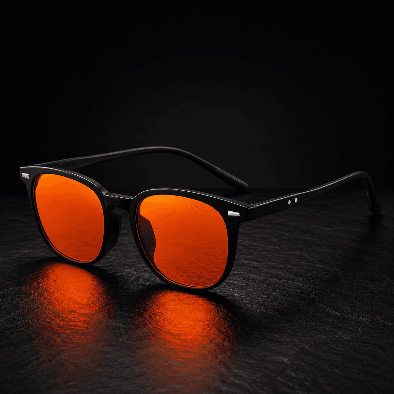 Vomando NightLens glasses with matte black frames and orange lenses on dark stone